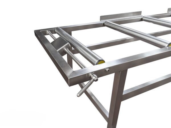 Vista lateral del carro de transporte con rodillos y estructura de acero inoxidable.